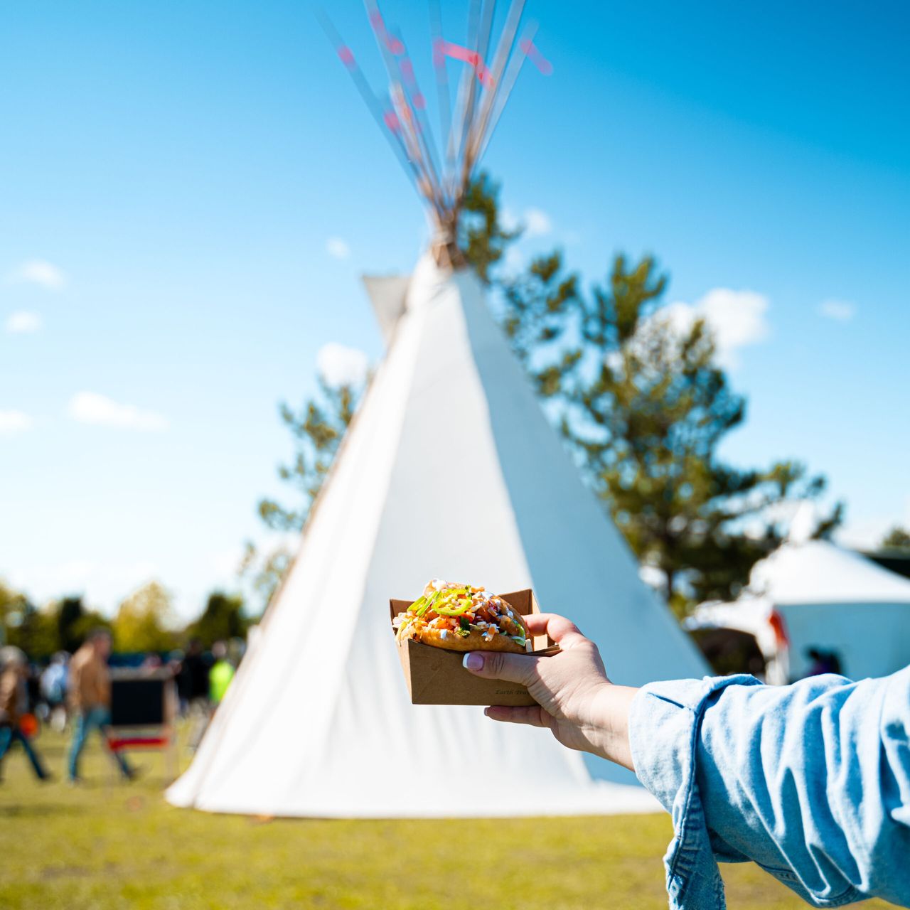 A person holding a bannock sandwich at the Indigenous Village at the Cloverdale Rodeo & Country Fair